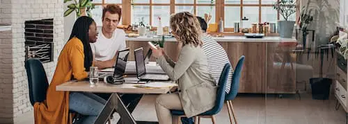 A group of diverse professionals working together at a table, collaborating on a project.