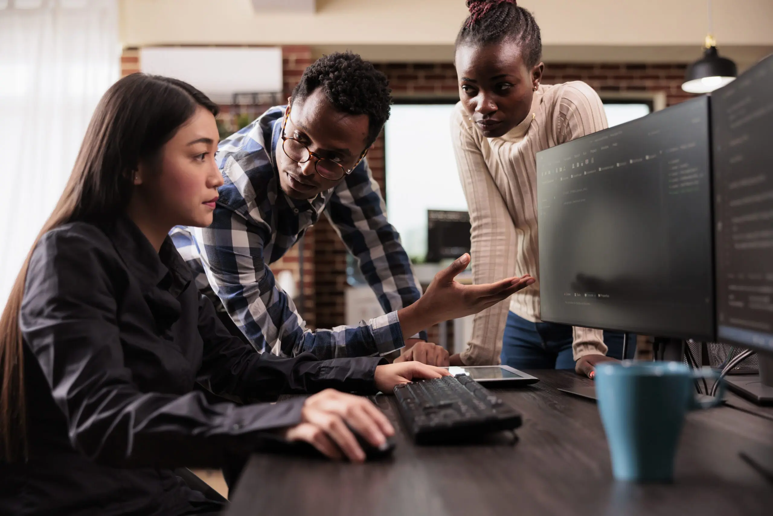 A group of diverse AI cloud programmers discussing HTML script and examining code on a computer screen while working on server interface development. The programmers are shown parsing through a cloud computing project that includes big data in an agency setting. This image highlights the use of AI in recruitment, as these programmers are leveraging cutting-edge technology to develop and implement complex systems. The use of AI in recruitment can help identify candidates with the necessary skills and expertise to excel in these roles, ensuring that businesses have access to the best talent available.